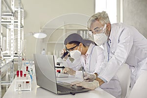 Microbiologist biotechnology researcher in facial mask conducting experiment