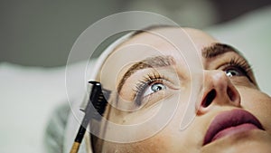 Microblading eyebrows workflow in a beauty salon.Woman having brows tinted by beautician,cosmetic procedure for the eyebrow