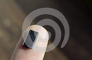 Microchip on a finger, microchip pins match the lines of the fingerprint, concept, bio-integrated electronics