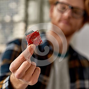 Microchip in hand of blur partial male technician