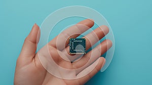 Microchip resting on a human hand against blue background