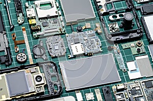 Microchips, semiconductor components and precious metals on the Board of disassembled old mobile phones photo