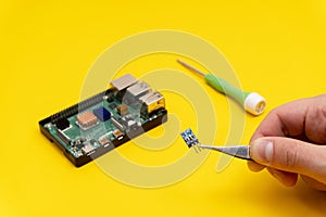 Microcomputer, scrwdriver on yellow background photo