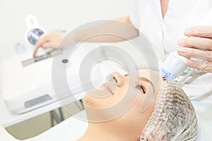 Microcurrent facial dermatology procedure. Model. Aesthetic radiofrequency treatment. Micro current cosmetology massage photo