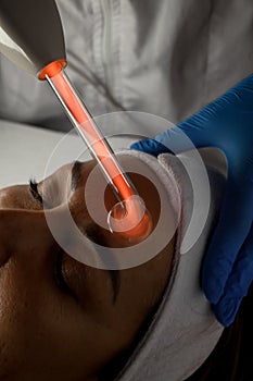 Microcurrent procedure of facial massage for a woman with closes eyes