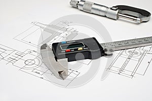 A micrometer and digital caliper on a white