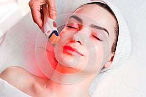 Microneedle facial mesotherapy with red light photo