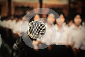 Microphone on abstract blurred of front podium and speech in seminar room or speaking conference hall light, Event meeting bokeh