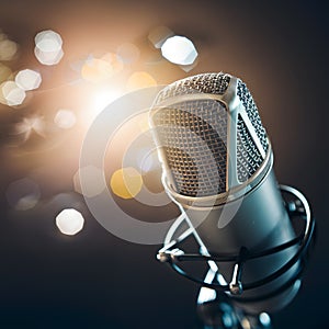 Microphone against bright bokeh background, close up studio shot