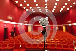 Microphone on a background of red hall with seating for spectators