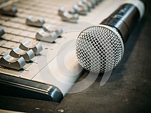 Microphone on the blur sound mixer background.