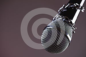 Microphone with a chain, depicting the idea of freedom of the press or freedom of expression on dark background. World press