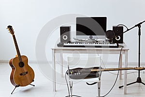 Microphone, computer and musical equipment guitars and piano background. Home recording studio concept.