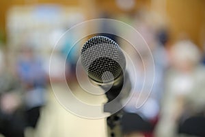 Microphone in concert hall or conference room with defocused bokeh lights in background. Extremely shallow dof