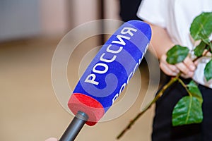 The microphone of a correspondent of the Rossiya TV channel is in the hands of a journalist who is interviewing in the