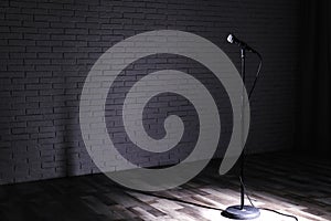 Microphone on dark stage near brick wall