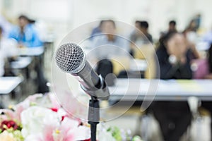 Microphone on the desk in meeting room with blur people background photo