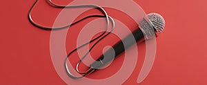 The microphone with a dynamic cable on a vibrant red background..AI generated image