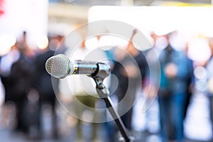 Microphone in focus against blurred audience. Public relations - PR concept