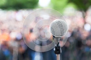 Microphone in focus against blurred protest or public demonstration