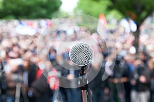 Microphone in focus against blurred protest or public demonstration