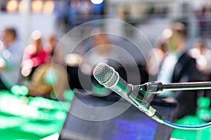 Microphone in focus, blurred audience in the background