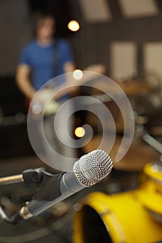 Microphone in focus. guitar player in out of focus