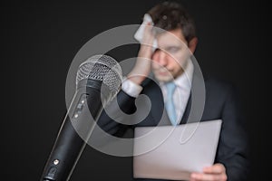 Microphone in front of a nervous man who is afraid of public speech and sweating