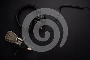 Microphone with headphones. Studio recording, broadcasting, blog, speaker. On a black background