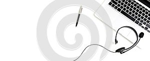 Microphone headset with notebook computer and pen on white table