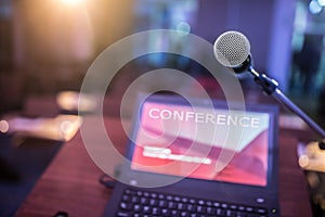 Microphone and laptop computer at podium on business seminar in conference room