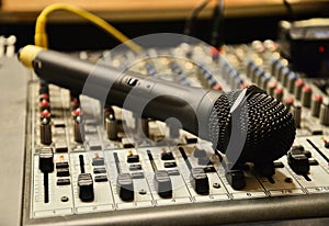 Microphone laying on the sound mixer. Professional audio equipme