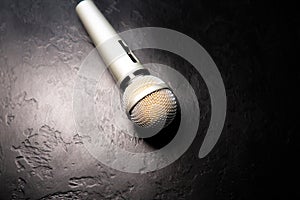 Microphone lying on the black background. Free time activities at home. Karaoke hobby. Music concept