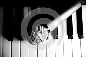 Microphone lying on the piano keyboards. Free time activities at home. Karaoke hobby. Creating music