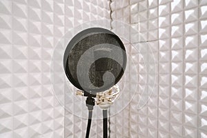 Microphone on mic stand in soundproof isolation booth for vocal recording at sound studio