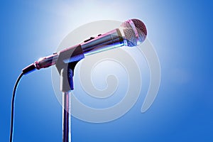 Microphone on microphone stand with blue background