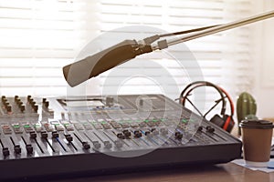 Microphone near professional mixing console in radio studio