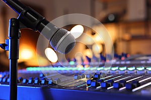 Microphone near professional mixing console in radio studio, closeup