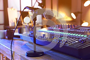 Microphone near professional mixing console on table in radio studio