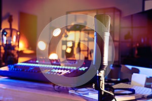 Microphone near table with professional mixing console in radio studio