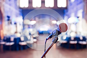 Microphone over the Abstract blurred photo of conference hall or wedding banquet background