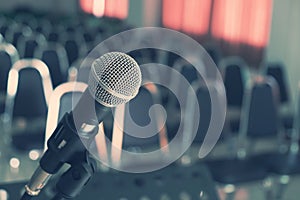 Microphone over the Blurred Chairs in the Conference hall.