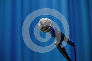 Microphone On Pedestal With Blue Theater Curtain