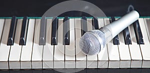 Microphone on piano keyboard. White and black. Music