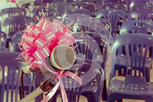 Microphone with pink bow and ribbon in the background of blue ch