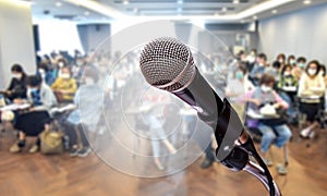 Microphone on podium in front blurred In seminar room or meeting room lighting. Business concept.