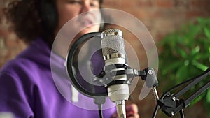 Microphone with pop filter closeup, blurred man talking for radio broadcast Spbd. Male announcer