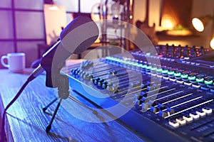 Microphone and professional mixing console on table in radio studio