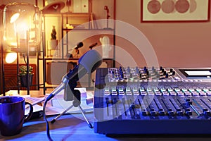 Microphone and professional mixing console on table in radio studio