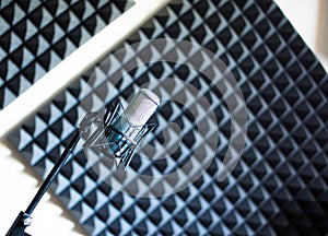Microphone in a professional recording or radio studio, sound insulation in the blurry background